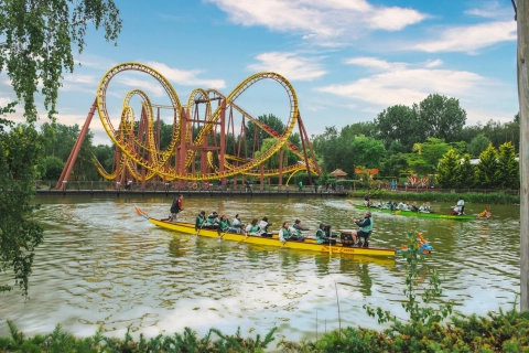 Photo montrant une attraction du Parc Astérix en ainsi que des personnes qui rament ensemble sur un bateau sur le lac du Parc Astérix