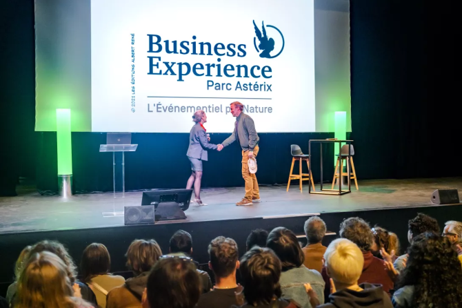 Photo montrant une audience et des personnes qui se serrent la main sur la scène du Théâtre Panoramix.